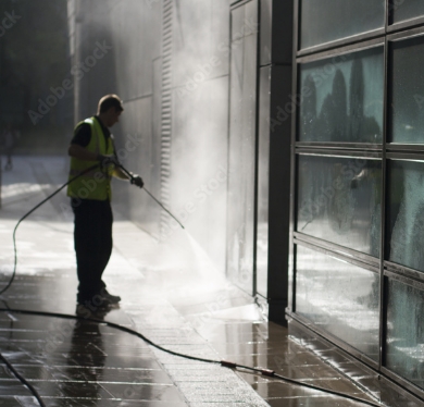 Man pressure washing commercial building